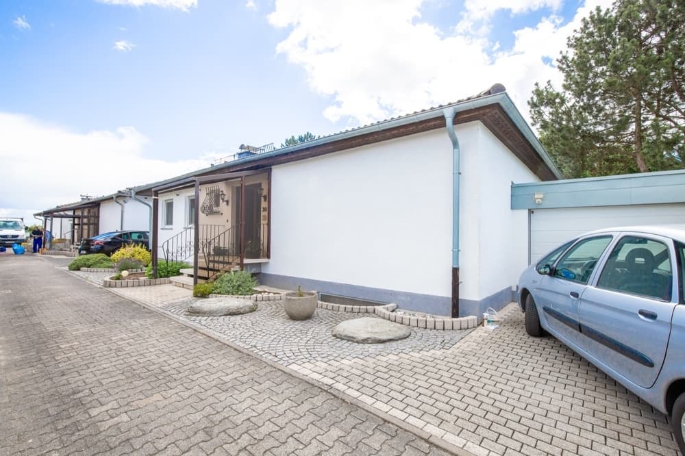 Strassenansicht — Winkelbungalow Delkenheim: 130 m² Wohnfl + voll ausgebauter Keller – bis ~190 m² fürs Wohnen nutzbar