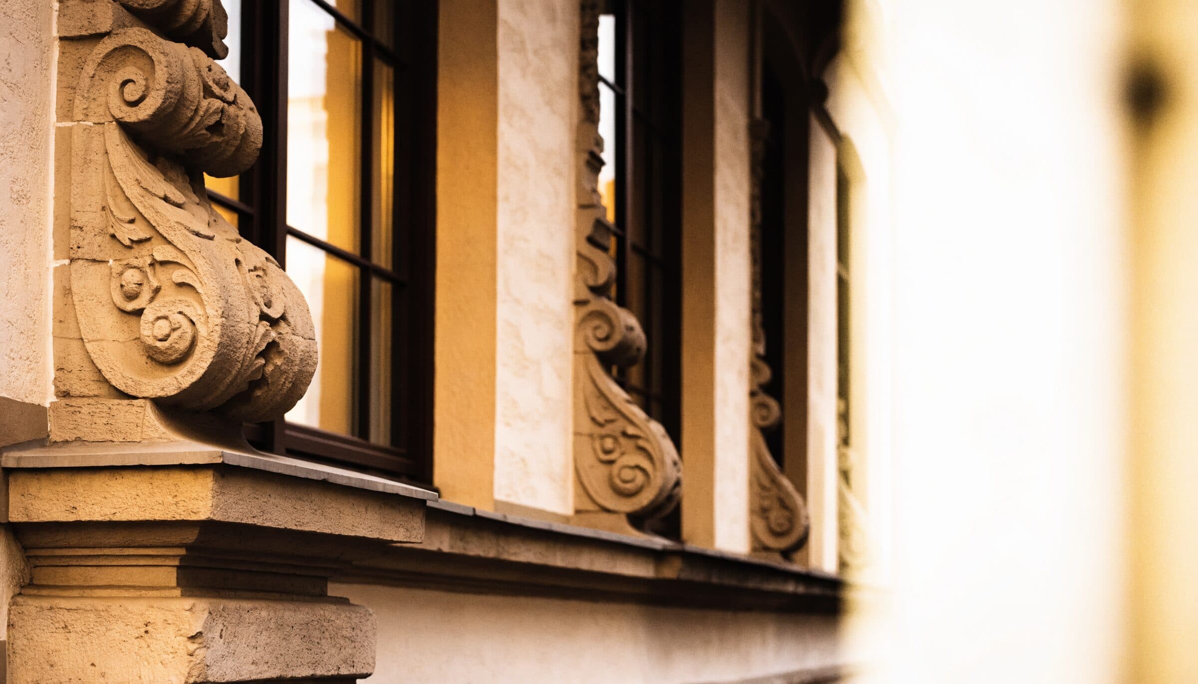 Sandsteinornament und Fenster einer Gründerzeitfassade im Abendlicht, Symbolbild